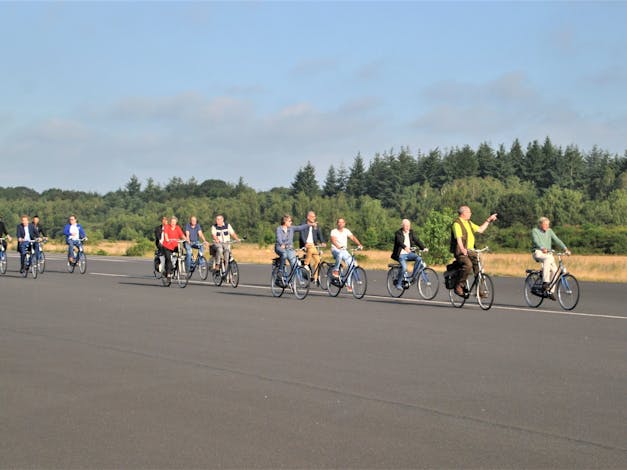 fietsers met gids op landingsbaan