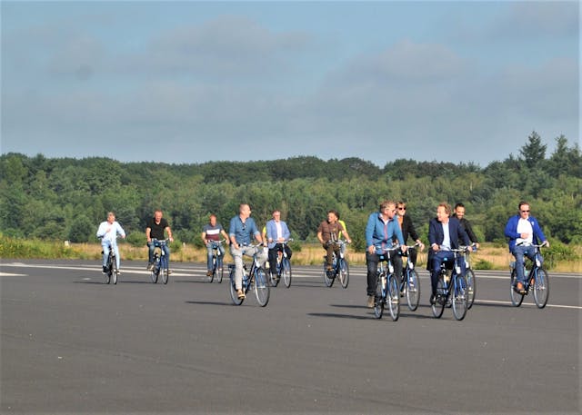 bedrijfsvrienden op de fiets over landingsbaan