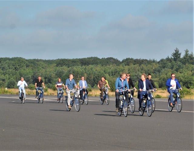 bedrijfsvrienden op de fiets over landingsbaan