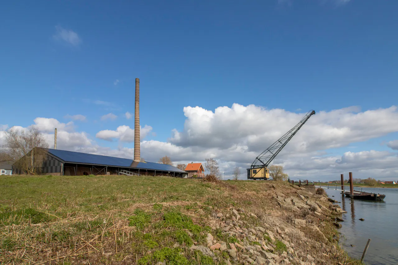 Steenfabriek Bosscherwaarden met kraan langs rivier