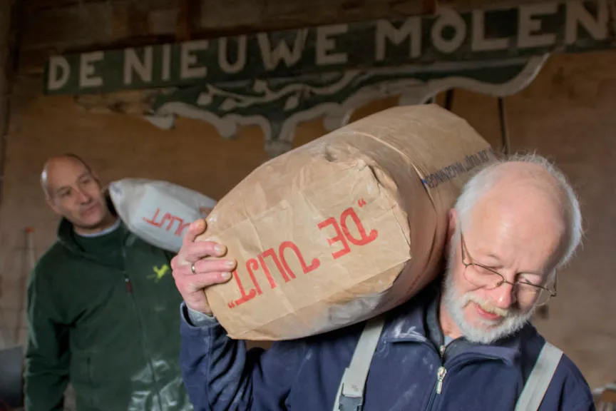 molenaars met zakken meel in De Nieuwe Molen