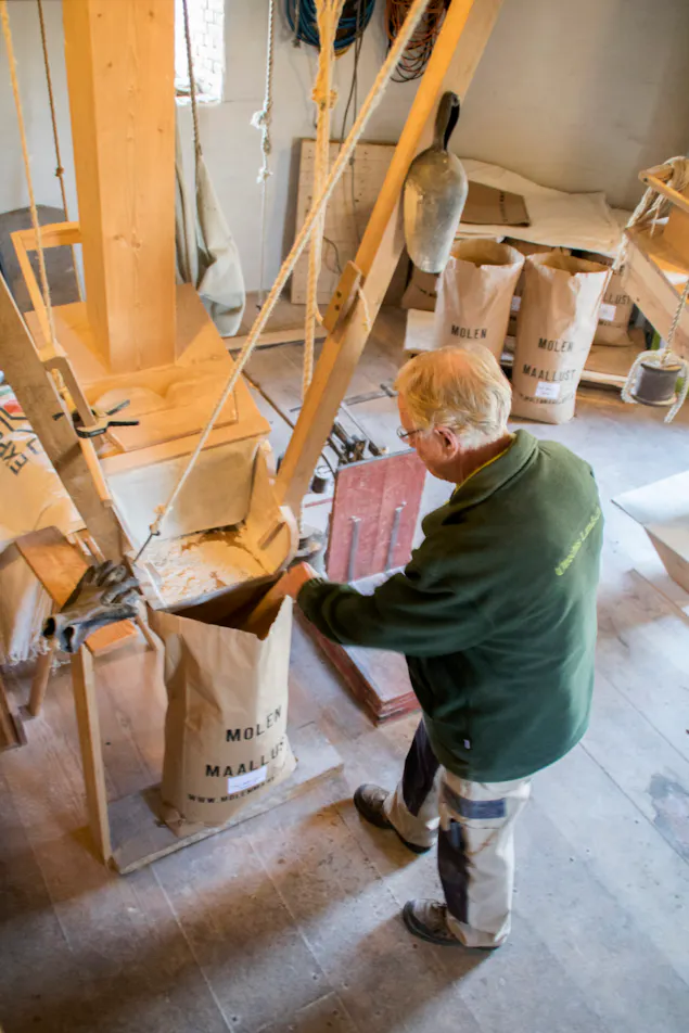 molenaar met meel in Molen Maallust
