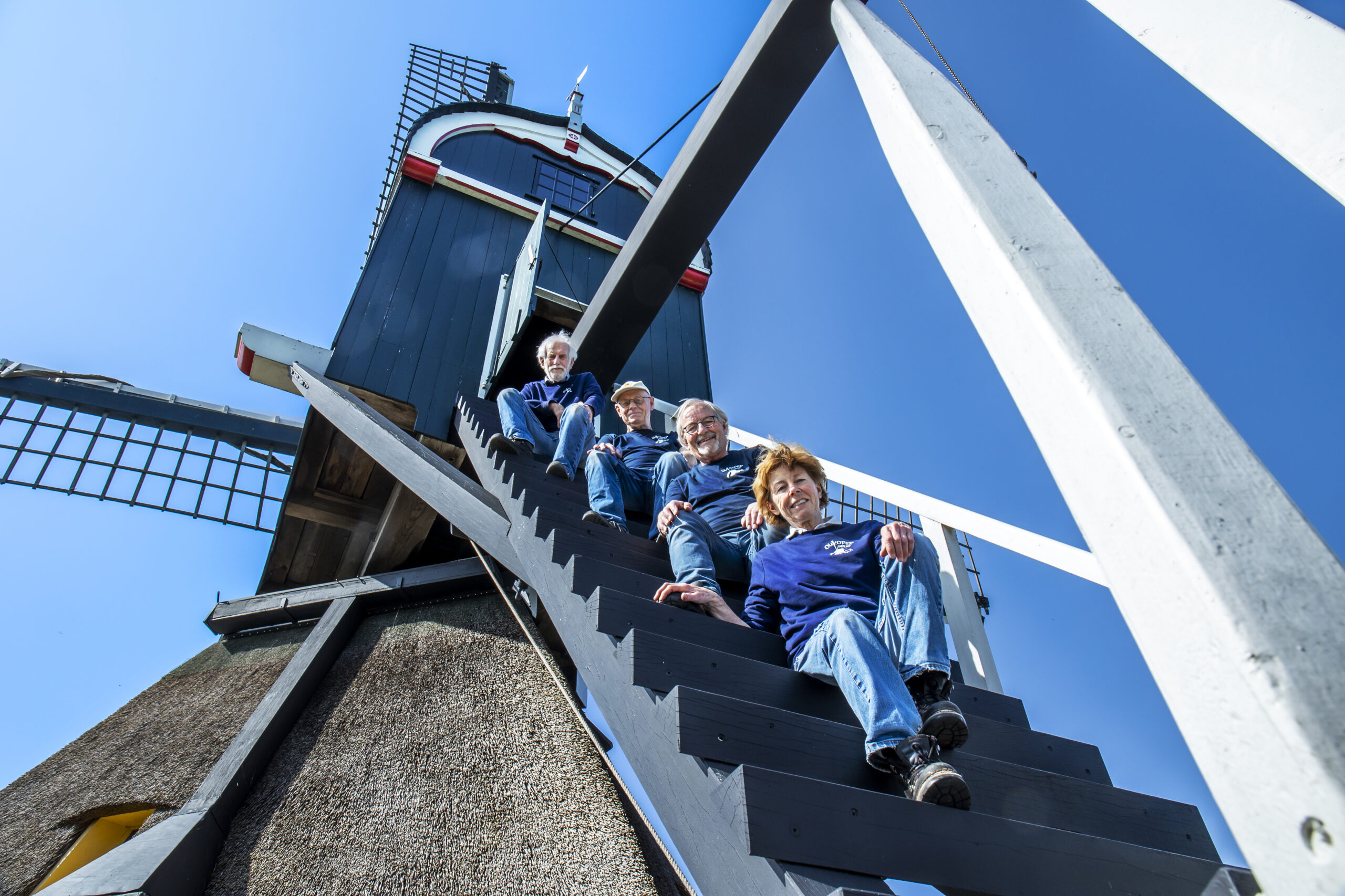 Vier molenaars poseren op de Oukoper Molen