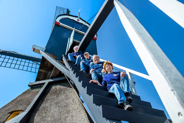 Vier molenaars poseren op de Oukoper Molen